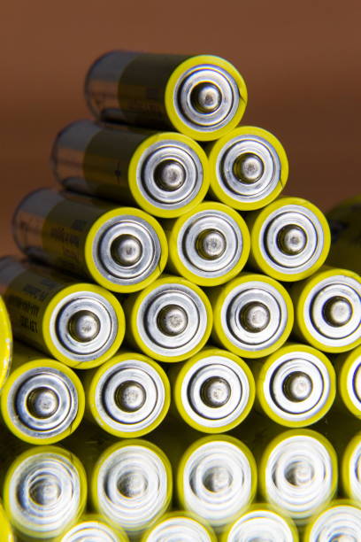 istock Stack of yellow AA batteries close up abstract coloured background 886605210