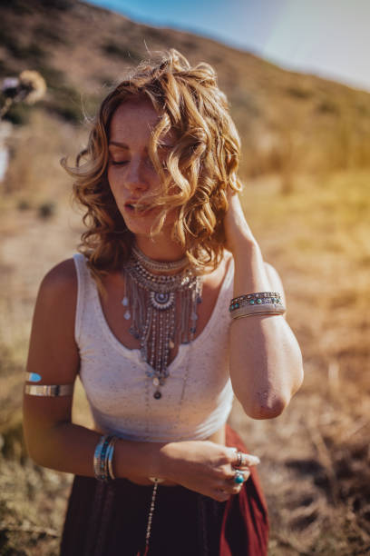 istock Beautiful young redhead woman in boho style standing in field 886624718