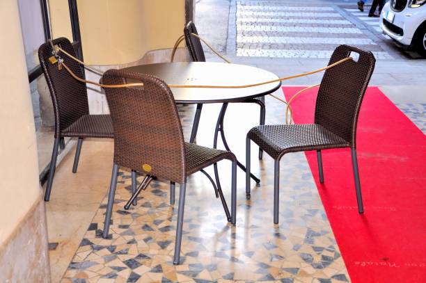 istock Chairs and round table outside the bar. In chains to prevent theft during the night. 886630404