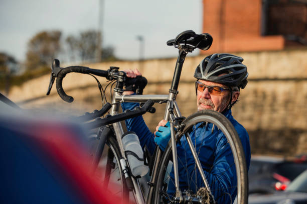 senior hombre quitar ciclo de portabicicletas - bicycle rack fotografías e imágenes de stock