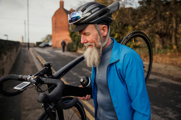 A Senior Man carries his Bicycle down some Steps
