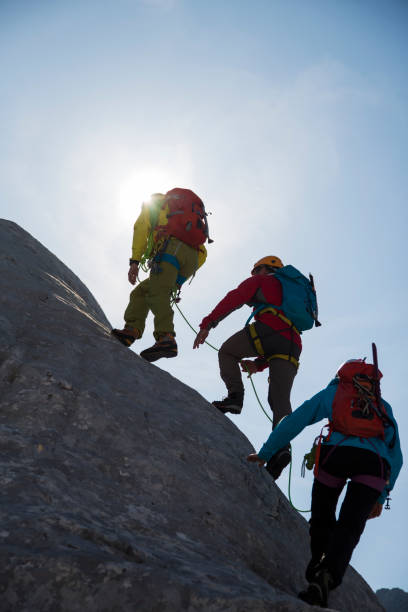 istock Hikers climbing on a rock mountain 886638880