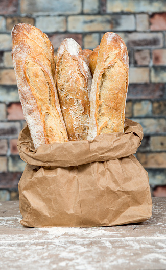 the fresh baked rustic bread loaves in paper bags