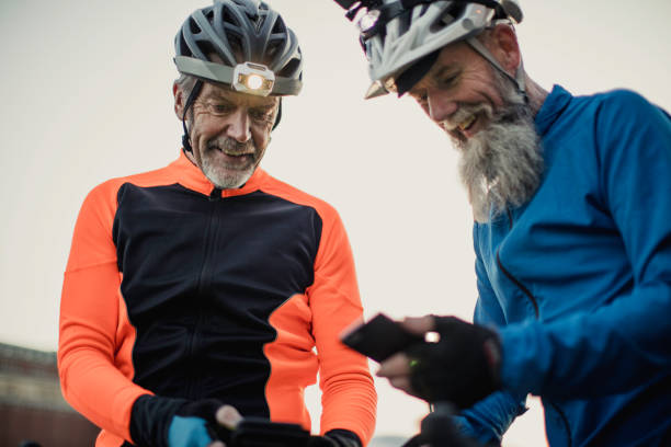 istock Two Older Cyclists One  Wearing a Helmet Camera Holding a Phone 886639046