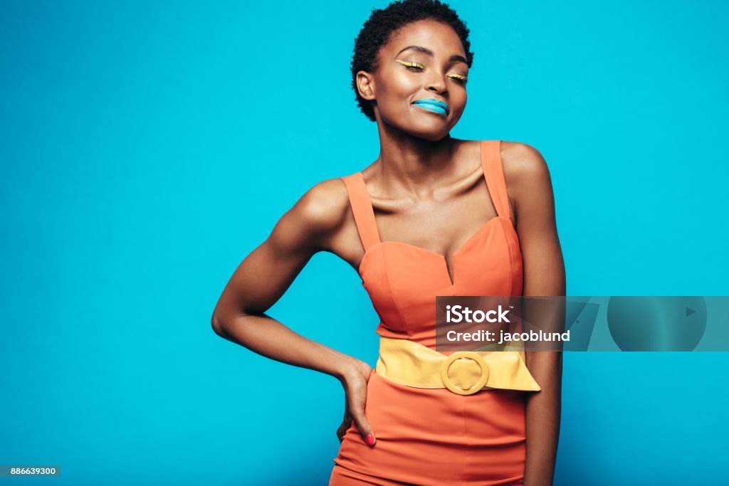 Beauty shot of woman with vibrant makeup Beauty shot of woman with vibrant makeup. Portrait of female model with vivid makeup standing against blue background. One Woman Only Stock Photo