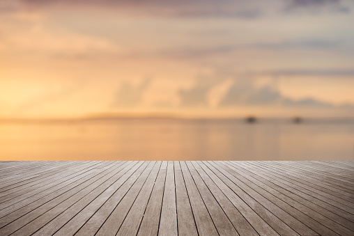Wooden platform with sunset over the sea background