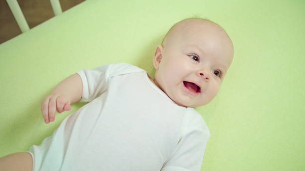 istock Baby Lying in a Crib at Home and Smiling 886639712