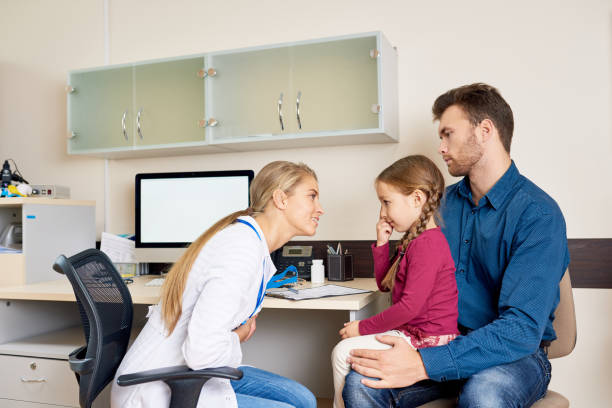 istock Father and Daughter in Doctors Office 886643586