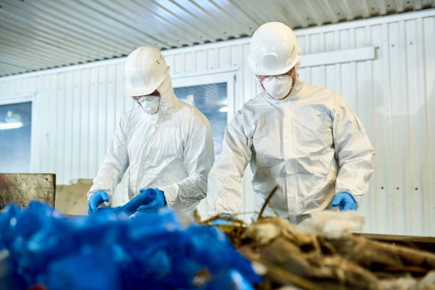 cernita dei rifiuti sugli impianti di riciclaggio - radiation protection suit clean suit toxic waste biochemical warfare foto e immagini stock