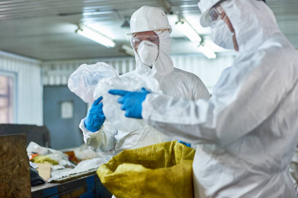 lavoratori che smistano la plastica nei moderni impianti di trattamento dei rifiuti - radiation protection suit clean suit toxic waste biochemical warfare foto e immagini stock