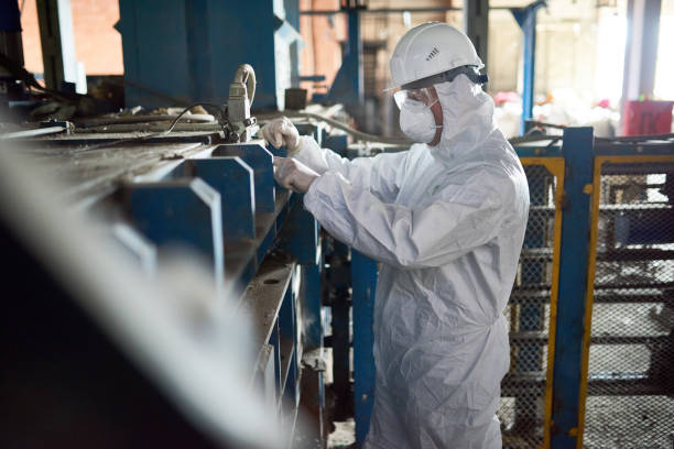 operaio in tute hazmat presso modern factory - radiation protection suit clean suit toxic waste biochemical warfare foto e immagini stock