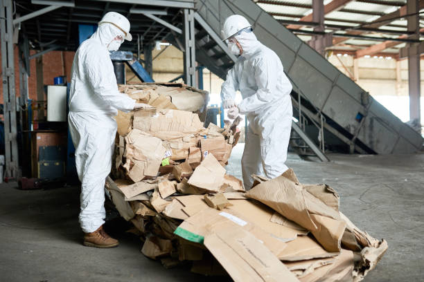 istock Workers in Hazmat Suits Sorting Cardboard at Modern Factory 886646454