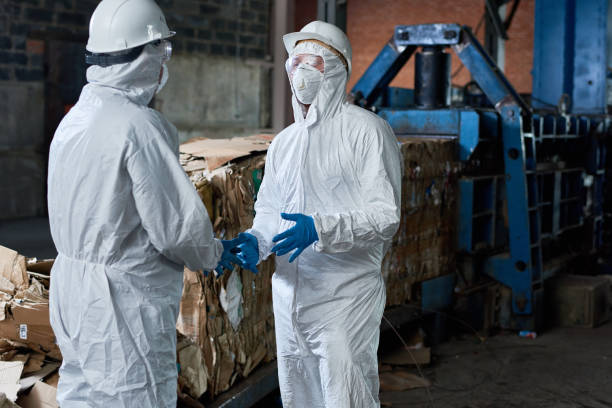 istock Workers in Hazmat Suits Communicating at Factory 886646462