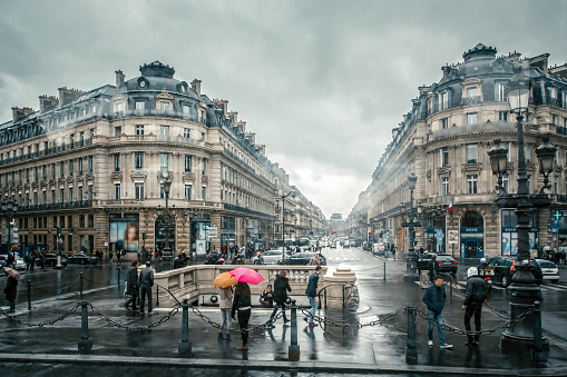 People with colored umbrellas in the streets on a rainy day on the streets of Paris, France