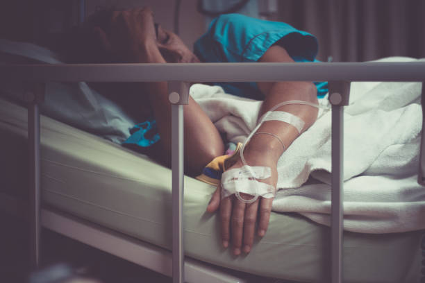 donna malata sdraiata a letto in ospedale. - braccialetto di identificazione foto e immagini stock
