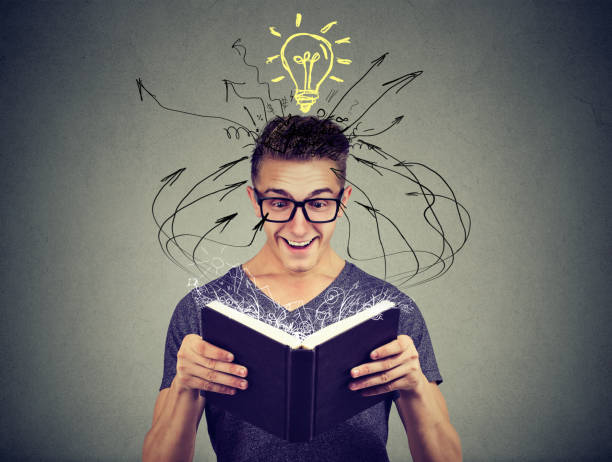 istock Happy man reading a book with light bulb above head 886658886