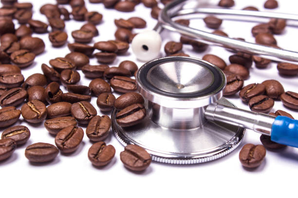 istock Coffee and stethoscope on white background. A small dose of coffee cures and a big kill 886675922