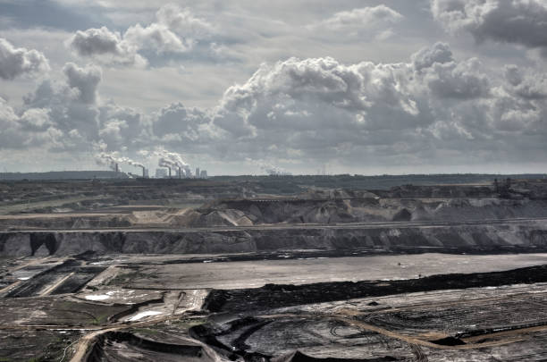 Lignite-fired power plants behind a brown coal mine with dramatic clouds and emissions These lignite-fired power plants are among the largest in Germany and Europe. They promote climate change through their CO2 emissions. They cause the highest greenhouse gas emissions of all European power plants. The particulate matter produced also contributes to environmental pollution. emission nebula stock pictures, royalty-free photos & images