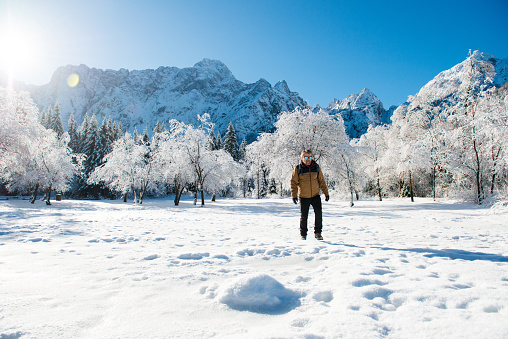 Senior man in the mountains in Winter. Lago di Fusine, Italy, Alps, Europe. All logos removed. Nikon.