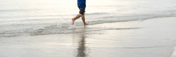 istock Men running on the beach and sea water 886679326