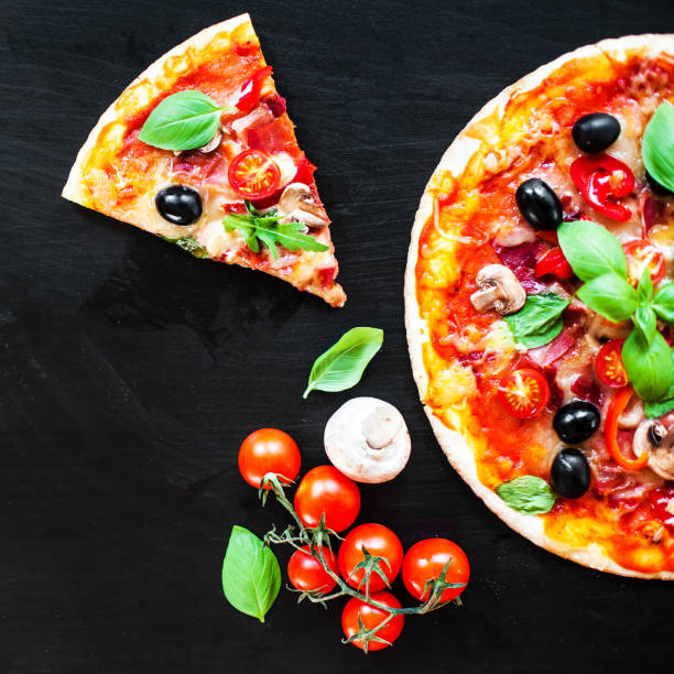 istock Hot pizza with Mozzarella cheese and tomatoes,  served om a black slate table board 886685682