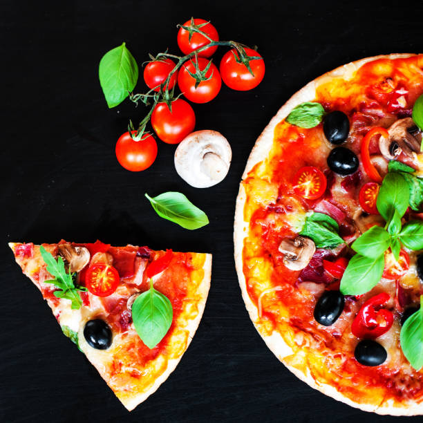 istock Pizza slice with Pepperoni,  Mozzarella cheese and tomatoes,  served om a black slate table board 886685684