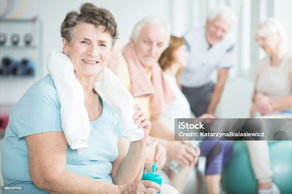 Happy senior woman with towel Happy senior woman with towel after stretching classes with friends Senior Adult Stock Photo