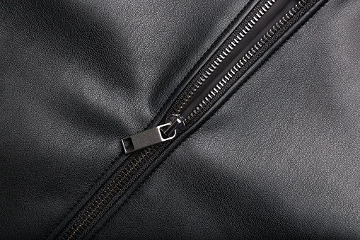opened zip on black leather surface