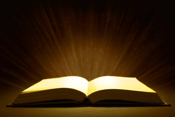 istock glow of rays from an open book on a dark background 886712256