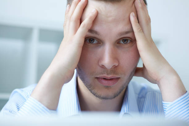 istock Feeling tired. Frustrated young handsome man looking exhausted while sitting at his working place. 886734180