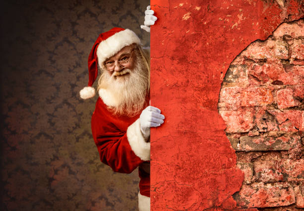 istock Santa Claus pointing on brick wall 886740668