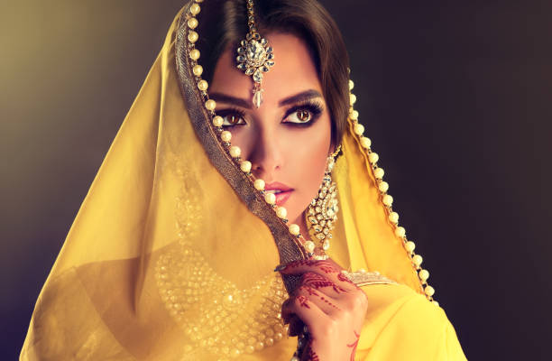 젊은 인도 여자의 초상화를 닫습니다 흰색 진주와 노란색 천을 사용 하 여 얼굴의 부분을 닫는입니다. - veil human face women fashion model 뉴스 사진 이미지