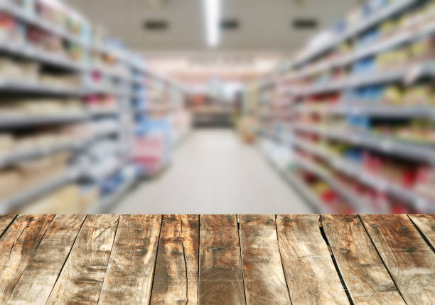 istock Wood board over blurred supermarket 886750380