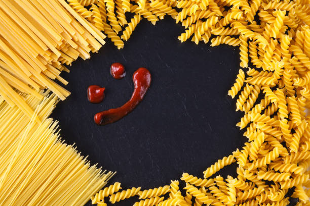 istock Frame from uncooked paasta on slate with ketchup 886750758