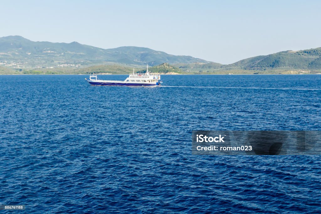 Ferry boat is in transport, passing over sea View on horizon with a ferry boat that is crossing over calm sea. Above Stock Photo