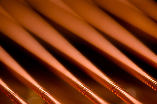 A macro shot of the wound-copper strings on a grand piano