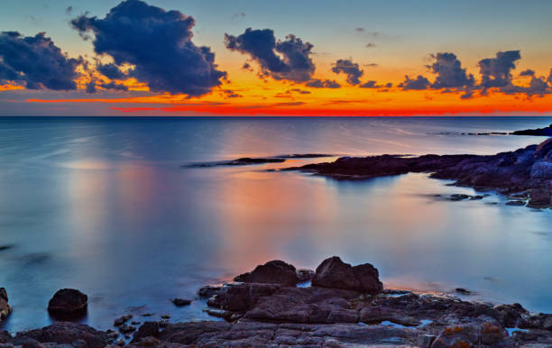 istock Sunrise on rocky shore and dramatic sky clouds 886776122