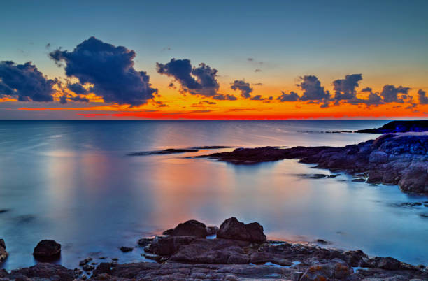 istock Sunrise on rocky shore and dramatic sky clouds 886776142