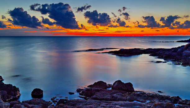 istock Sunrise on rocky shore and dramatic sky clouds 886776204