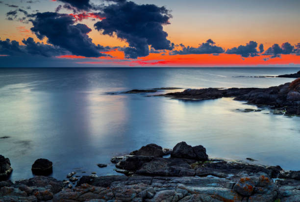 istock Sunrise on rocky shore and dramatic sky clouds 886776410