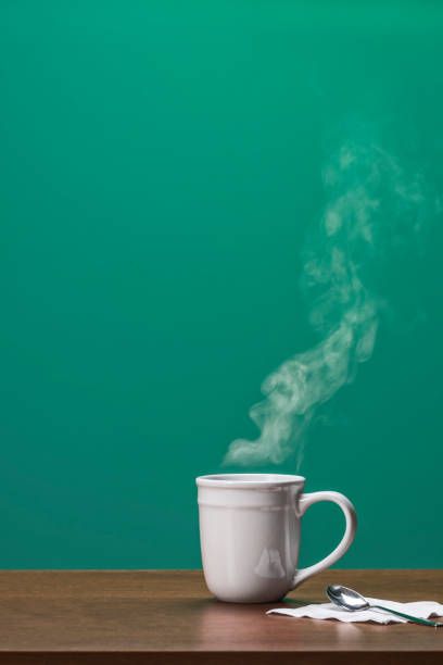 istock Large white mug with a steamy hot coffee or tea on a wooden table 886776742