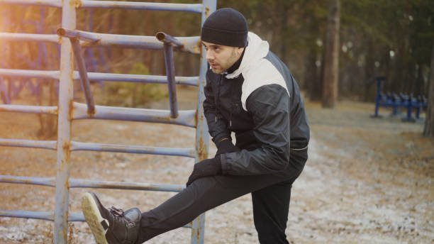 istock Attractive man runner doing stretching exercise preparing for morning workout and jogging in winter park 886782774