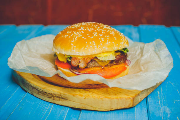 istock Fresh beef burger with cheese, blue wooden background 886785640