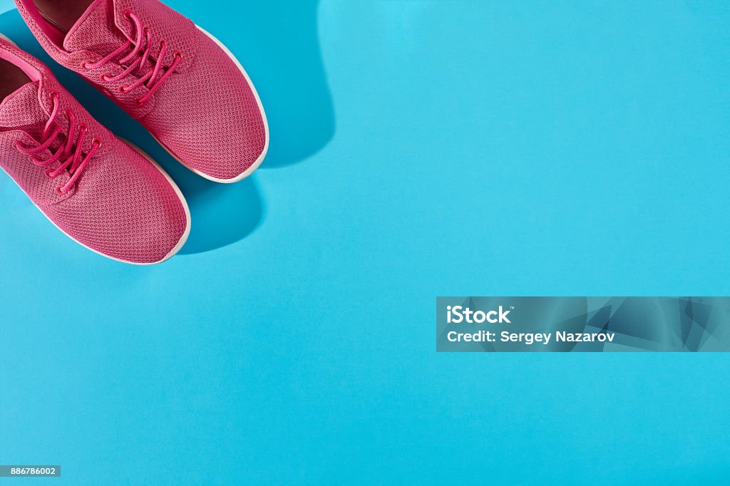 Neue rosa Turnschuhe auf blauem Hintergrund mit Textfreiraum. Sport-Konzept - Lizenzfrei Schuhwerk Stock-Foto