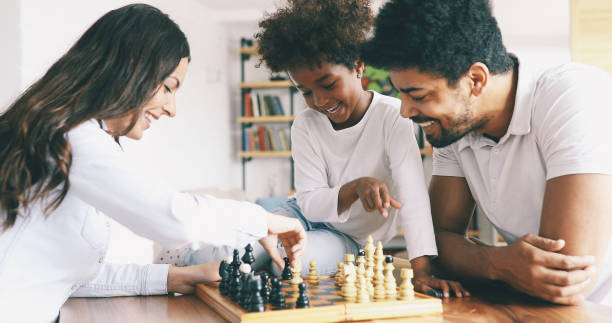 istock Happy family playing chess together at home 886790920