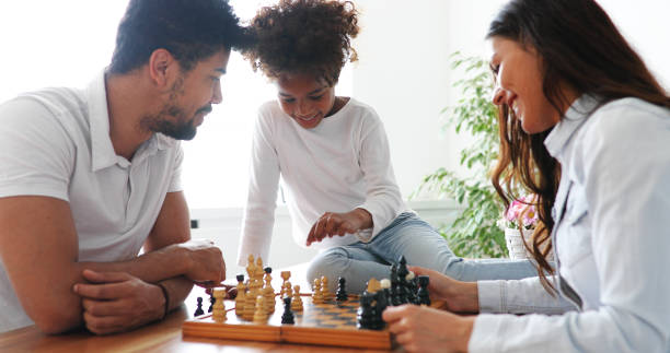 istock Happy family playing chess together at home 886791096