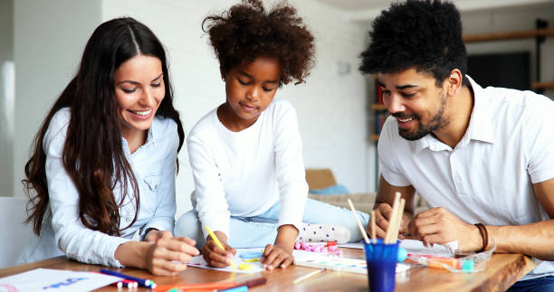 istock Mother and father drawing together with their child 886796690