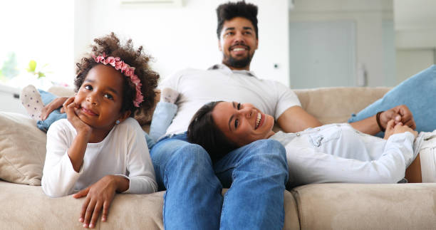 istock Young girl watching tv with her parents 886797478