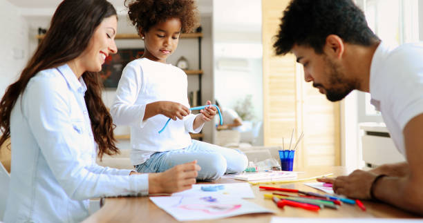 istock Mom and dad drawing with their daughter. 886797788