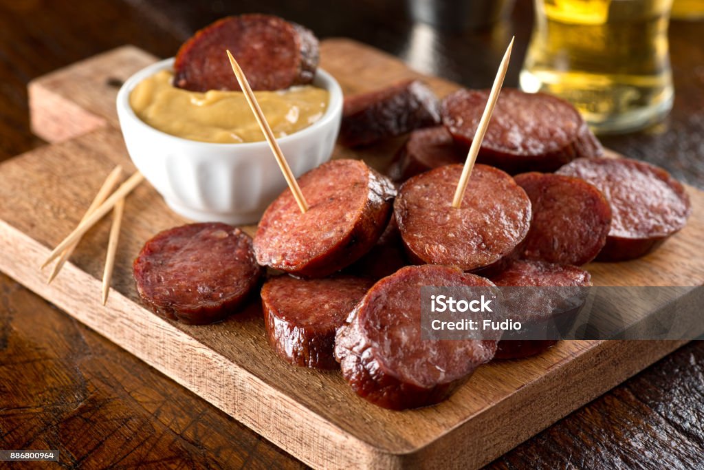 Deep Fried Pepperoni Delicious pub style deep fried pepperoni on a wood serving board. Appetizer Stock Photo